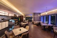 um restaurante com mesas e cadeiras e uma cozinha em Grand Mercure Shenzhen Guangming em Shenzhen