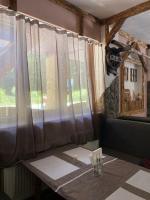 Una mesa de comedor con una ventana con cortinas. en Готель-кафе Чатина, en Soymy