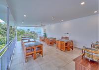 um restaurante com mesas e cadeiras na varanda em Ice Mist Pool Resort Munnar By VOYE HOMES em Munnar