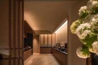 Atour Hotel Haikou Longhua Jinniuling Park في هايكو: ممر مع مطبخ مع الزهور على الحائط