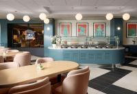 a restaurant with tables and chairs and a counter at Sonesta Los Angeles Airport LAX in Los Angeles