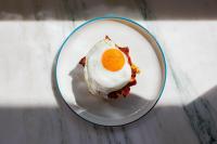 a fried egg on a plate on a table at Ace Hotel & Swim Club Athens in Athens
