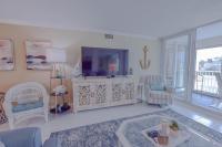 ein Wohnzimmer mit Flachbildfernseher und Stühlen in der Unterkunft Shoreline Towers #3022 in Destin