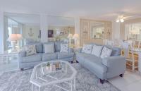 ein Wohnzimmer mit zwei blauen Sofas und einem Tisch in der Unterkunft Shoreline Towers #3022 in Destin