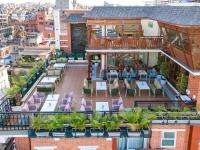 an outdoor patio with tables and chairs on a building at Timber House by Tara Group in Kathmandu