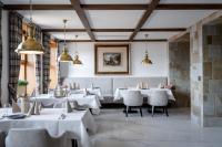 Un comedor con mesas y sillas blancas. en Osada Seidorf, en Karpacz