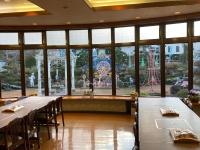a restaurant with tables and chairs and a large window at 令德湖畔山荘 in Yamanakako