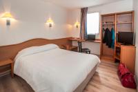 a hotel room with a bed and a desk and a television at BRIT HOTEL Essentiel CAHORS Nord in Cahors