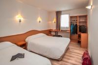 a hotel room with two beds and a television at BRIT HOTEL Essentiel CAHORS Nord in Cahors