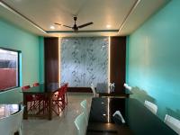 a dining room with a table and a ceiling fan at Alpine Resort in Sivasagar