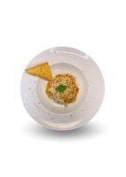 Un recipiente blanco con un trozo de comida encima. en Vrata Hotel Yogyakarta, en Kalasan