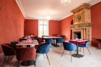 Un comedor con mesas y sillas y una chimenea. en Château de Roques, en Teilhet