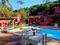 a table and chairs next to a swimming pool at Pousada ZEN Cumuruxatiba in Cumuruxatiba
