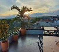een balkon met een tafel en stoelen en een palmboom bij Hotel Luna Verde in Doradal