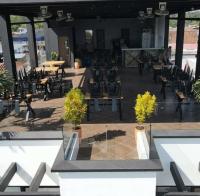 een grote patio met tafels, stoelen en planten bij Hotel Luna Verde in Doradal