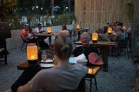 um grupo de pessoas sentadas às mesas de um restaurante em Koh Kood Garden House em Ban Lak Uan