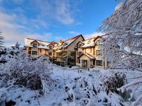 a large house covered in snow in a yard at Malachit Karpacz SPA Hotel in Karpacz