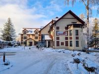 a large building with snow on the ground at Malachit Karpacz SPA Hotel in Karpacz