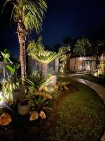 una casa con palmeras en un patio por la noche en Widji Garden Villa, en Uluwatu