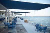 een terras met stoelen en tafels en het water bij Luxurious One Bedroom Apartment in Hurghada