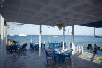 een restaurant met tafels en stoelen en de oceaan bij Luxurious One Bedroom Apartment in Hurghada