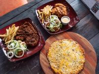 a table with two trays of food and french fries at Kruger Maroela Lodge in Marloth Park
