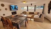 A television and/or entertainment centre at Casa Caledonia - Appartement dans villa avec jardin arboré et piscine à 500 M de la mer