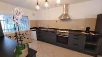 A kitchen or kitchenette at Casa Caledonia - Appartement dans villa avec jardin arboré et piscine à 500 M de la mer