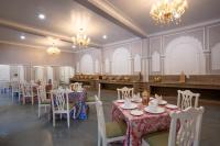 uma sala de jantar com mesas, cadeiras e lustres em JuSTa Alwarbagh Sariska em Alwar