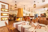 una sala da pranzo con tavolo e camino di Sun Stream Apartment a Pamporovo