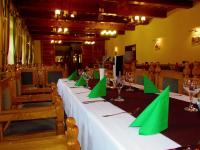 una mesa larga con servilletas verdes y copas de vino en Odvaskő Turistaház, en Bakonybél