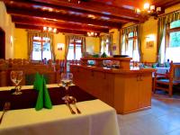 un restaurante con una mesa con copas de vino. en Odvaskő Turistaház, en Bakonybél