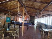 Una mesa de billar en una habitación con mesas y sillas. en Forest Bliss Resort, en Dehradun