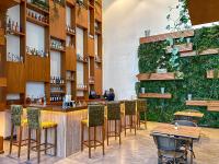 a bar in a restaurant with a green wall at Canal Central Hotel Business Bay in Dubai