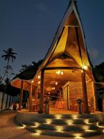 a large building with a triangular roof with lights at Linasi Resort Sri Lanka in Ahangama