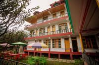 Un edificio con mesas y sombrillas delante. en LIGHTWORKERS Hostel & Cafe, en Kalgha