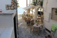 a restaurant with tables and chairs on the beach at Theofanis Studios in Agia Anna Naxos