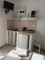 a small kitchen with a sink and a bed in a room at Theofanis Studios in Agia Anna Naxos