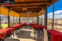 un ristorante con tavoli e sedie rossi e ampie finestre di Belenus Cave House a Ürgüp