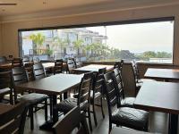 VengurlaBaywatch Resort Bhogave Beach的一家餐厅，里面有桌椅和一个大窗户。
