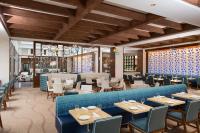 a restaurant with a blue couch and tables and chairs at The Coral at Atlantis in Nassau