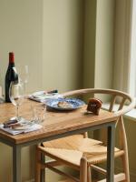 a wooden table with a plate of food and a bottle of wine at Nest Farmhouse in Docking