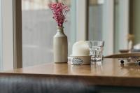 a table with a vase and a candle and a glass at Nest Farmhouse in Docking