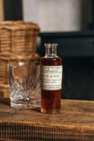 a bottle of whiskey sitting on a table next to a glass at Nest Farmhouse in Docking