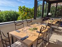 una fila de mesas en una habitación con ventanas en Hôtel La Petite Bohème, en Le Lavandou
