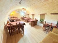 Dostlar Konagi Gaziantep في Şahinbey: مطعم بطاولات وكراسي خشبية في الغرفة