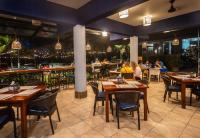 ハコにあるParadise Jaco Beach Frontのテーブルと椅子、座り人が並ぶレストラン