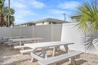 eine Reihe von Picknicktischen vor einem Zaun in der Unterkunft Cozy Beachside Bungalow Studio Ideal for Couples in Myrtle Beach