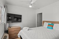 ein Schlafzimmer mit einem Bett und einem Flachbildfernseher in der Unterkunft 4BR2BA Sleeps 12 Pet-Friendly Steps to Beach in Myrtle Beach