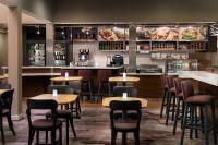 Un restaurante con mesas y sillas y un bar. en Courtyard Fremont Silicon Valley, en Fremont